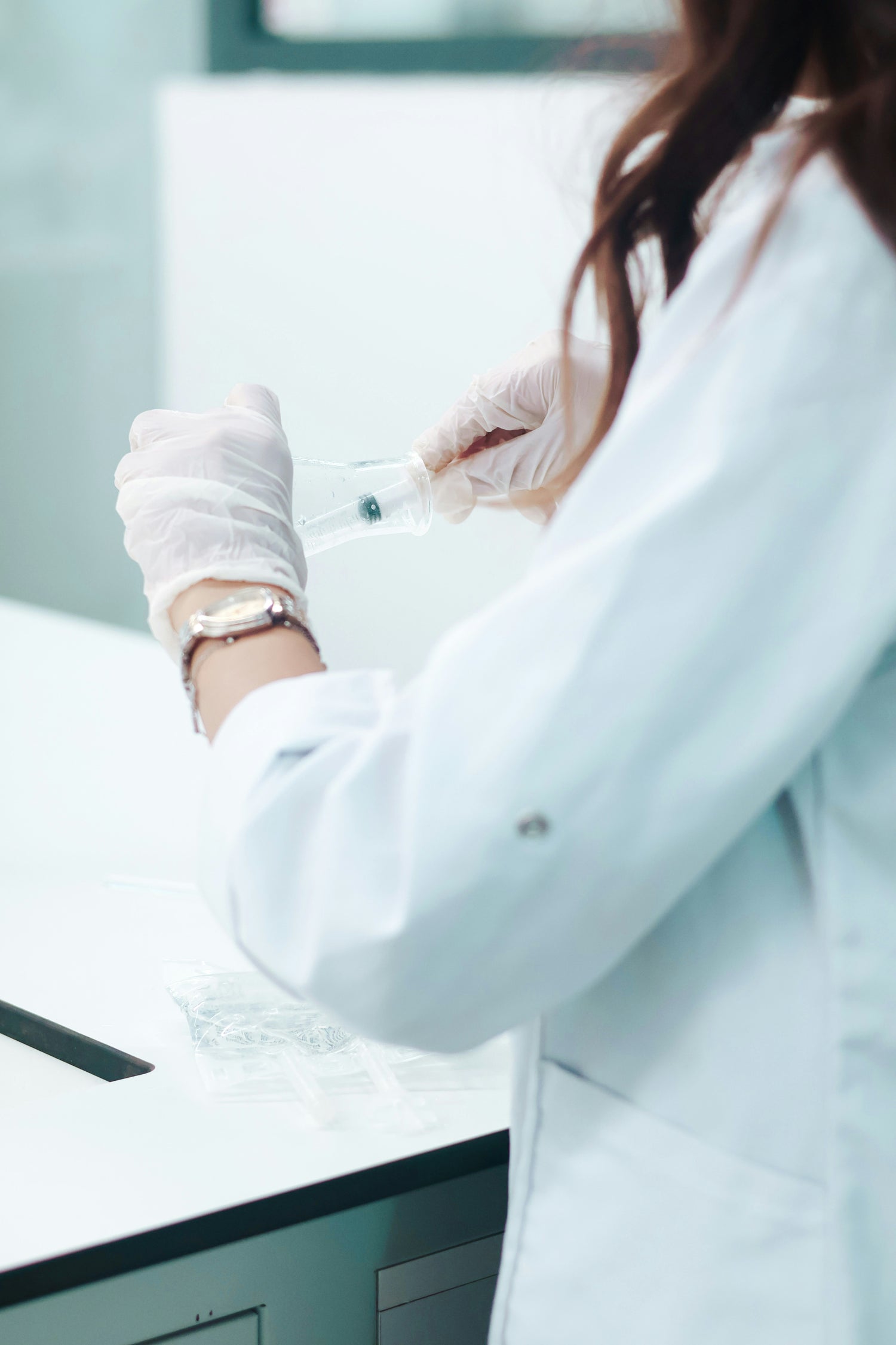 Scientist mixing clear liquids in a laboratory setting